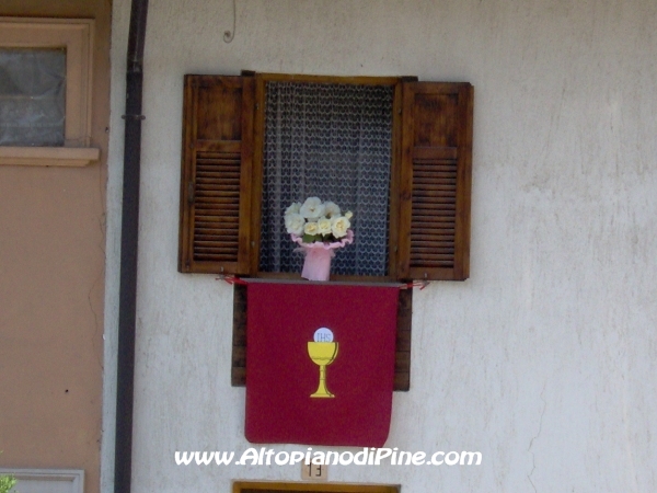 Le finestre del paese addobbate per la processione