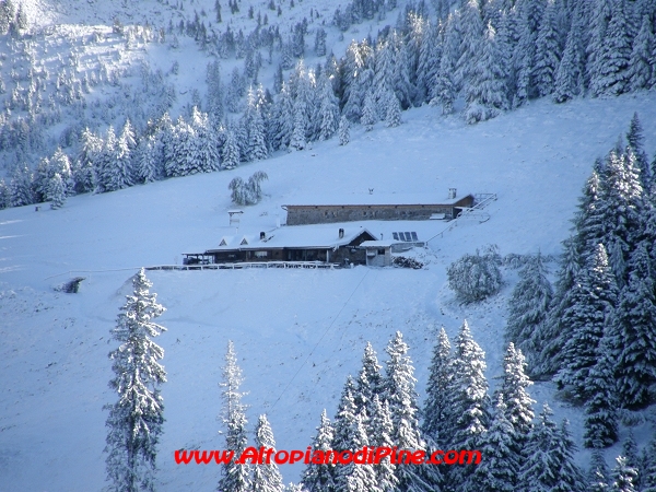 Rifugio Tonini ricoperto di neve visto dal sentiero che parte da Malga Stramaiolo