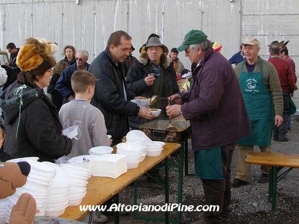 Gli Alpini che distribuiscono pasta, vin brule, the caldo