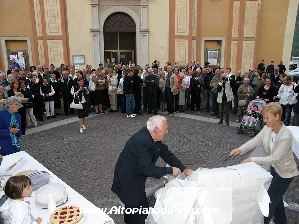 La gente e don Livio che scarta il  regalo