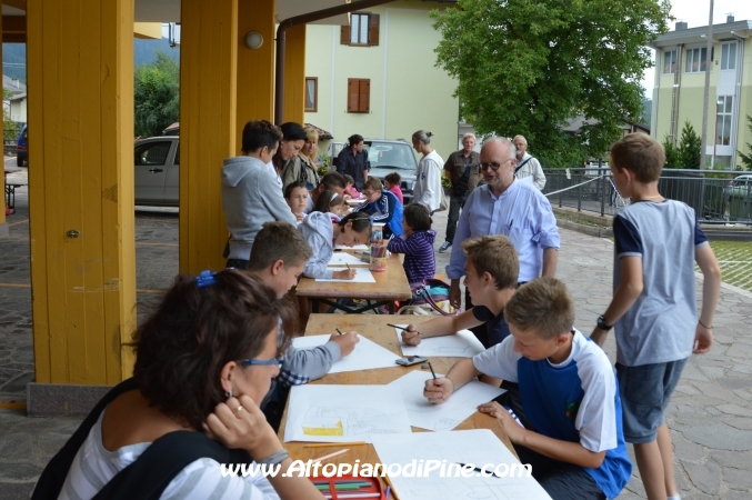 Don Stefano Volani, parroco di Miola, osserva i disegnatori.